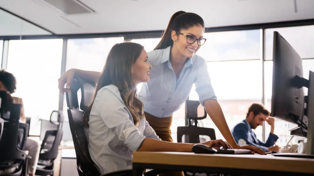Two marketers reviewing campaign results at a desk